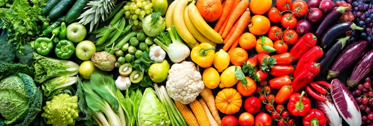 panoramic food background with assortment of fresh organic fruits and vegetables in rainbow colors
