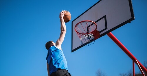 basketball player makes slam dunk