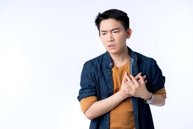 close up young asian male businessman casual costume hand touch heart with stroke heart attack with gesture action express ill sickness bad health ideas concept white background