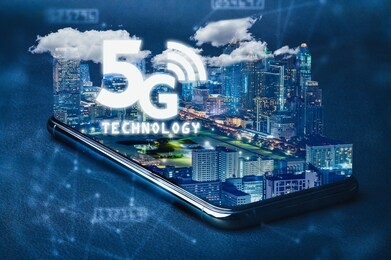 the abstract image of the smartphone laying on the table and overlay with futuristic cityscape and 5g hologram image. the concept of future, 5g, telecommunications, business and internet of things.