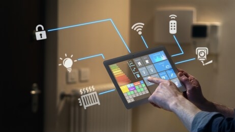 close up of a man hand is using a futuristic latest innovative technology glass tablet with augmented reality holograms as a remote control of smart home appliances at home or office.