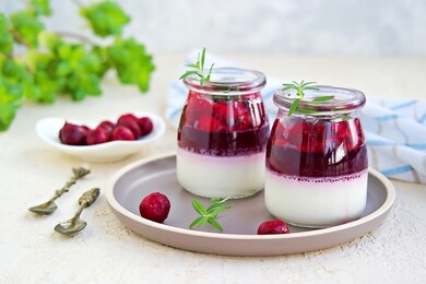 dessert, creamy panna cotta with cherry sauce in in vintage glass jars on a light concrete background. desserts without baking. desserts for valentine day. italian food