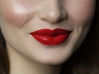 close-up happy female smile with healthy white teeth, bright red gloss lips make-up. cosmetology, dentistry and beauty care. macro of woman's smiling mouth