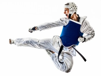 one caucasian man practicing taekwondo in studio isolated on white background