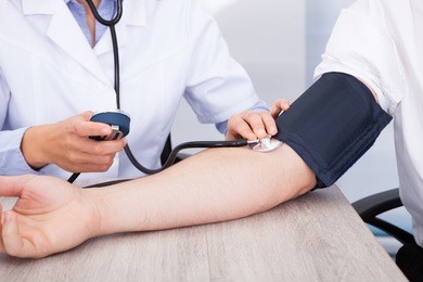 close-up of female doctor's hand checking blood pressure