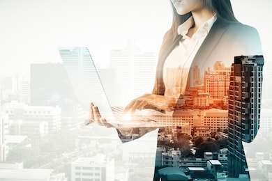 double exposure of businesswoman silhouette using laptop on city background. sucess and business concept