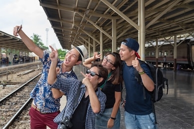 concept life style holidays travel or journey : young  asian tourists friend group are using mobile phones for selfies at train station area
