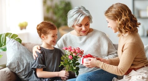  mother's day! three generations of a loving family mother, grandmother and daughter congratulate on the holiday, give flowers

