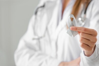female doctor with parkinson's awareness ribbon in clinic, closeup