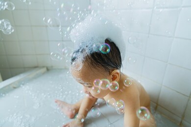asian baby shower in bathroom, playing with yellow duck and soap bubbles