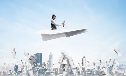 screaming pilot sitting in paper plane and holding steering wheel. aviator driving paper plane in blue sky above falling paper sheets with infographics. cityscape with skyscrapers and office buildings