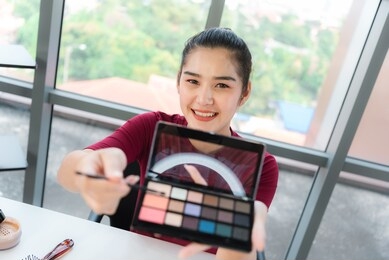 blogger,recording video tutorial online concept.young asian woman makeup artist youtuber influencer broadcasting demonstrating her cosmetic product live online.