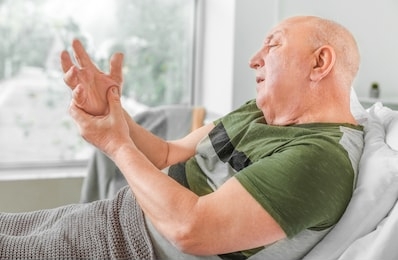 senior man suffering from parkinson syndrome in clinic