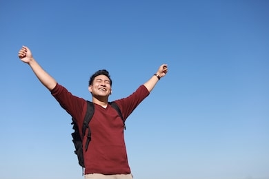 happy traveler asian man in red shirt by the sea.