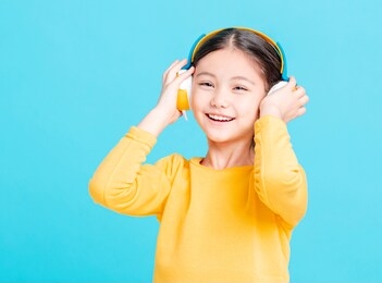 happy little girl   listens to music in headphones