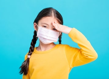 sick girl child in medical mask isolated on blue background
