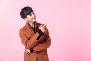 asian a man handsome young pointing with two hands and fingers to the side eyes looking at camera in love isolated on pink blank copy space studio background.