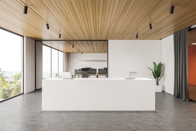 interior of modern office hall with white and orange walls, concrete floor, comfortable white reception desk with two laptops on it and open space area in background. 3d rendering