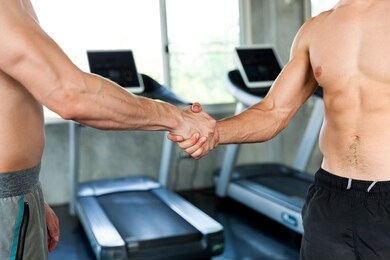 beautiful muscles of athletes, muscular arm, sportsman doing exercises and shaking hands in sport gym, athlete makes exercise, bodybuilder, sport fitness and muscles concept