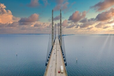 the oresund bridge between copenhagen denmark and malmo sweden during sunset over the sea.