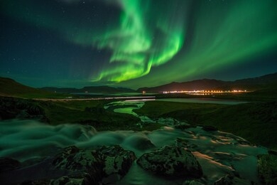 aurora borealis overlooking small town in iceland