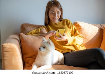 asian woman sit on sofa with her dog at home