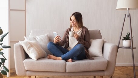 video call. cheerful young woman with coffee talking with friends on cell phone, panorama