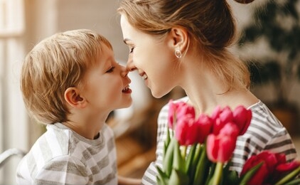 happy mother's day! child son congratulates mother on holiday and gives flowers
