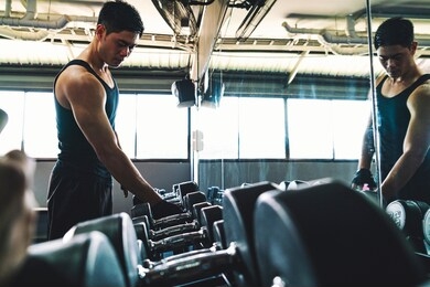 asian man wearing sportswear lifting barbell and other training equipment for his healthy and strong muscles, sports and healthy concept