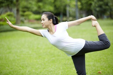 healthy middle aged asian woman doing fitness and yoga stretching in the park