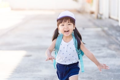 back to school concept.happy funny little asian girl running and very excited and glad when she go back to school.happy toddler child from kindergarten school.school kid girl with japan bag.education.