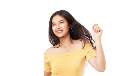 young attractive asian woman wearing yellow t-shirt moving jumping forward with happy smiley face isolated on white background.