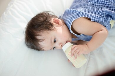the little girl is drinking milk happily