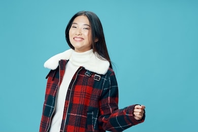 beautiful woman asian appearance winter jacket fun smile blue isolated background