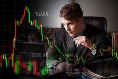 a man in a black suit stares at the computer screen. a person on the background of numbers and graphs. trading session on the exchange. demonstration of changes in stock prices.