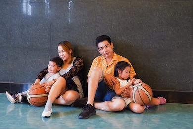 asian family playing basketball together