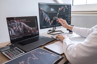 stock exchange market concept, business investor trading or stock brokers having a planning and analyzing with display screen and pointing on the data presented and deal on a stock exchange.