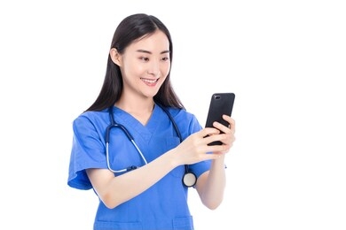 young nurse sending a message with the mobile on isolated blue background