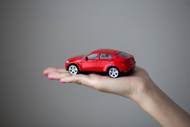 closeup photo of woman hand holds a little car toy