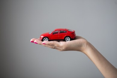 closeup photo of woman hand holds a little car toy