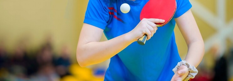 ping pong table, woman playing table tennis with racket and ball in a sport hall