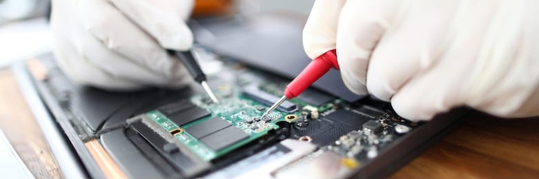 close-up of circuit board in laptop. technician soldering microchip using welding machine. professional at computer service working on pc maintenance. man in gloves fixing electronics and gadgets