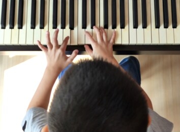 a child playing the piano , top view , blurred focus