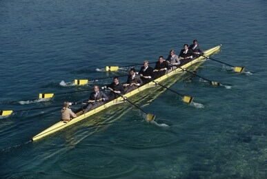 team of rowers in business suits