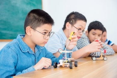 young asian boy studying in science classroom,making electric remote control car.