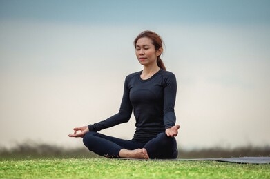female asian yoga meditation in the open field