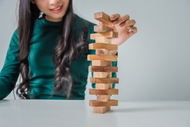 young business woman asian playing blocks wood game at table in the room.