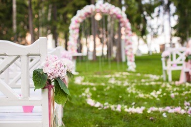 wedding benches and flower arch for ceremony outdoors