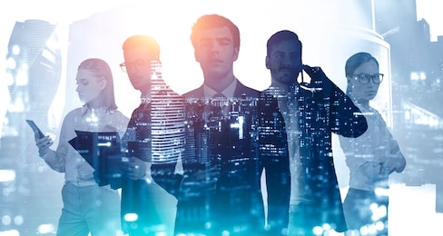 business success and partnership concept. silhouettes of young business people with double exposure of blurry abstract night city panorama. toned image.