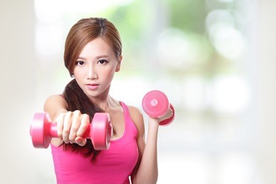 young sport girl with dumbbells with green background, asian